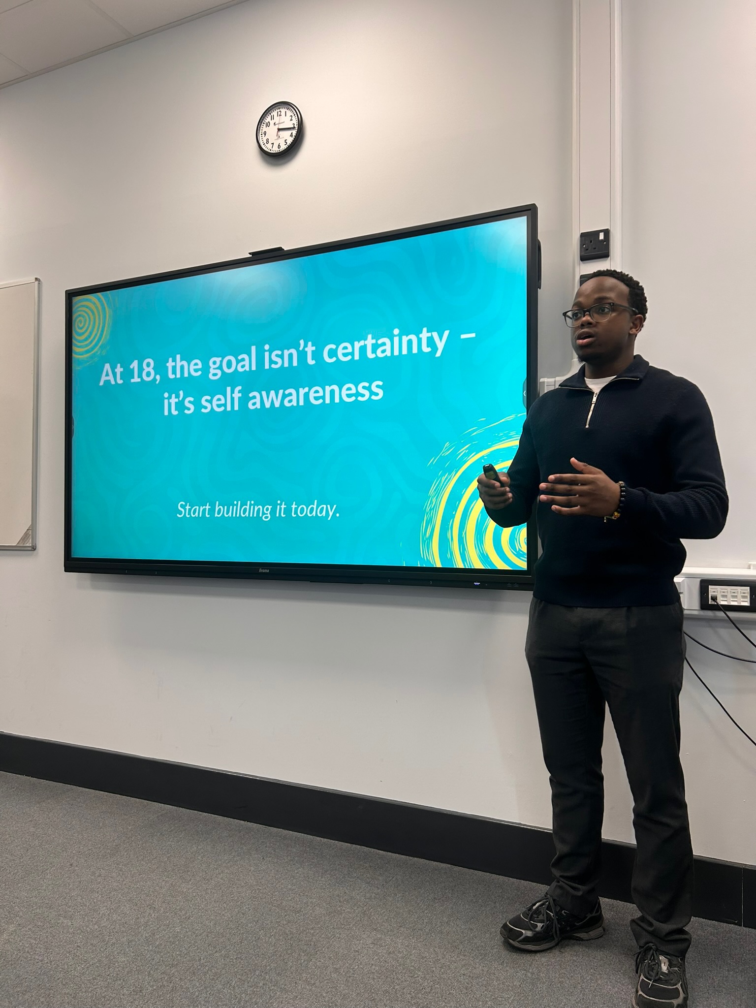 Chinonso Anatune speaking beside a slide that reads: at 18, the goal isn't certainty, it's self-awareness